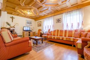 a living room with couches and a tv at Pineta Pastry Hotel in Rocca Pietore