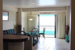 a living room with a table and chairs and a balcony at Hotel Playa Marina in Mazatlán