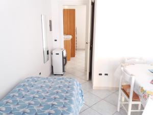 a bedroom with a bed and a room with a refrigerator at GRomano Apartments in Ischia Town