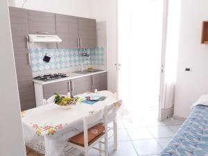 cocina pequeña con mesa blanca y fogones en GRomano Apartments, en Isquia