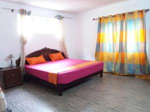 a bedroom with a bed with a colorful comforter at Rosidence Braban in Le Morne