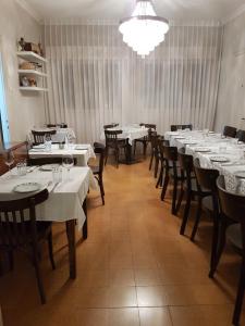 a dining room with white tables and chairs and a chandelier at Lishansky Since 1936 in Metulla