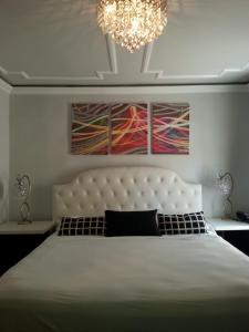 a bedroom with a large bed and a chandelier at Hollywood VIP Hotel in Los Angeles +29 photos