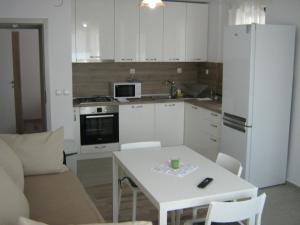 a kitchen with a white table and a white refrigerator at Khan Krum House & Apartments for rent in Elin Pelin