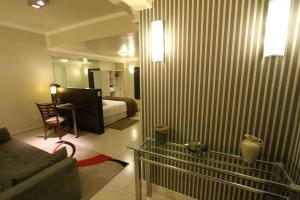 - un salon avec un canapé et une chambre dans l'établissement Hotel Curi Executive, à Pelotas