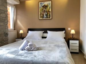 1 dormitorio con 1 cama con 2 toallas en Apartments Feral, en Trogir