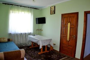 uma sala de estar com uma mesa em frente a uma porta em Karpatski Prostory em Slavske