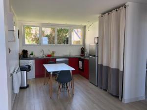 een keuken met rode kasten en een tafel met stoelen bij Villa Sainte Marguerite in Wimereux