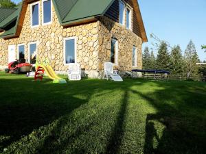 a house with a yard with chairs and a playground at Eco Resort Nad Karpatamy in Hrobyshche
