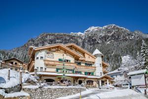 een skihut in de bergen met sneeuw op de grond bij Pineta Pastry Hotel in Rocca Pietore
