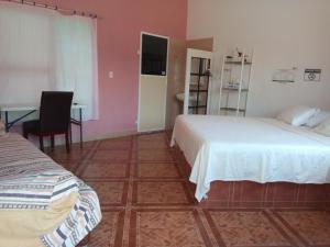 um quarto com 2 camas, uma mesa e uma secretária em Hospedaje Barrancas em Cosoleacaque