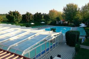 - une piscine avec un bâtiment en verre à côté dans l'établissement Agriturismo da Giovanni, à Peschiera del Garda