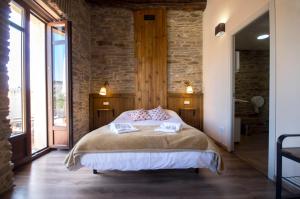 a bedroom with a bed and a brick wall at La Casona de Sarria in Sarria