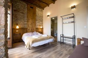 a bedroom with a bed and a stone wall at La Casona de Sarria in Sarria