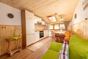 ein Wohnzimmer mit einem grünen Sofa und einem Tisch in der Unterkunft Ferienwohnungen Woferllehen in Berchtesgaden