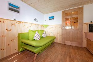 a green chair in a room with wooden walls at Ferienwohnungen Woferllehen in Berchtesgaden