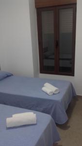 two beds with towels on them in a room at Hospederia Gomis 26 in Ontinyent
