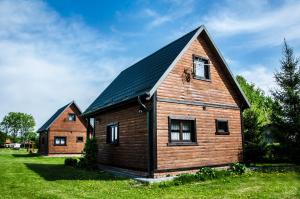 a large wooden house with a black roof at Domek nad Szelągiem in Kątno