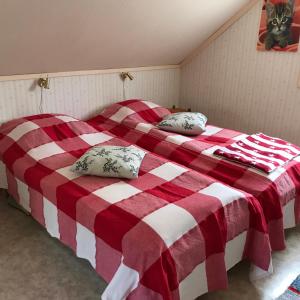 two beds in a bedroom with a red and white blanket at Borgdala Stugor in Ödkarby