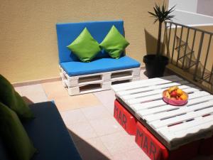 佩尼謝的住宿－佩尼切劍魚生態度假屋，蓝色椅子和一张桌子及一碗水果