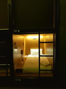 Sovotel @ Napzone KKIA في كوتا كينابالو: غرفة فندقية عليها سرير مع اضاءة