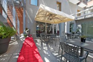 a red blanket on a patio with tables and chairs at Hotel Mercure Milano Solari in Milan