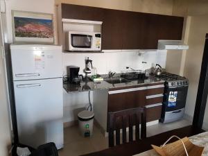 cocina con nevera blanca y microondas en Anamar en Salta