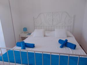 a bedroom with a bed with two blue pillows on it at Appartamenti in Villa Nicanda in Porto Columbu - Perdʼe Sali