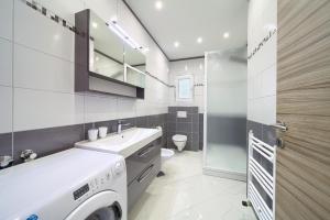 a bathroom with a sink and a washing machine in it at Apartments VALL in Krk +110 photos