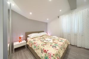 a bedroom with a bed with a floral bedspread at Apartments VALL in Krk