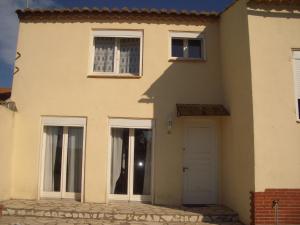 Casa blanca con puerta y ventanas blancas en Charmante chambre d'hôte, en Sigean