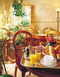 una mesa con pan y dos tazas de zumo de naranja en Hôtel Saint Roch, en París