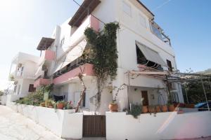 a white building with potted plants on the side of it at Niki Rooms in Palaiochora