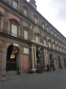 un gran edificio de ladrillo con una persona parada frente a él en La Dimora di Anna en Nápoles