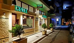 a store with neon signs on the front of a street at Hotel Nevada Kalamata in Kalamata