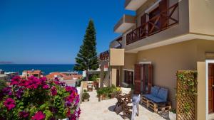 a balcony of a house with flowers and a view of the ocean at Avra Apartments in Kalyves