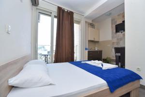 a large bed in a room with a large window at Apartments Jelušić in Budva