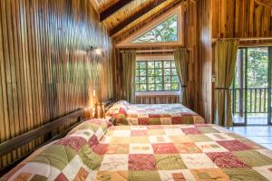 a bedroom with a bed with a quilt on it at Sueños del Bosque Lodge in San Gerardo de Dota