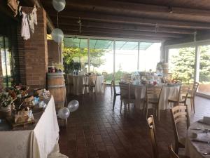 un comedor con mesas, sillas y ventanas en Casa De Campo, en Montegranaro