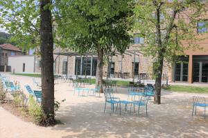 een groep stoelen en tafels voor een gebouw bij Le Felicien in Saint-Félicien