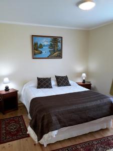 プエルト・バラスにあるCabañas Lago Azulのベッドルーム1室(大型ベッド1台、ナイトスタンド2台付)