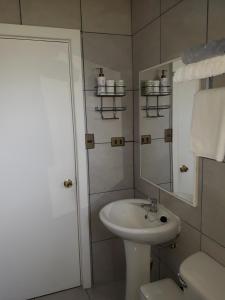 a white bathroom with a sink and a mirror at Cabañas Lago Azul in Puerto Varas