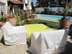 ヴィラ・ノヴァ・デ・ミルフォンテスにあるCasa dos Cactosのパティオ(テーブル、椅子付)、プールが備わります。