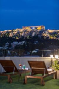 a park bench overlooking the ocean with a view of a city at The Athens Version Luxury Suites in Athens