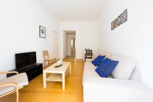 ein Wohnzimmer mit einem weißen Sofa und einem Tisch in der Unterkunft The Trendy Prince Lisbon Apartment in Lissabon