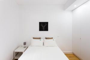 - une chambre blanche avec un lit blanc et des murs blancs dans l'établissement The Trendy Prince Lisbon Apartment, à Lisbonne