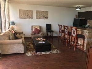 a living room with a couch and a bar at Waikiki Banyan in Honolulu