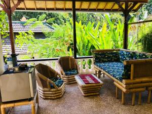 un portico con sedie, divano e tavolo di White Lotus Oasis ad Ubud