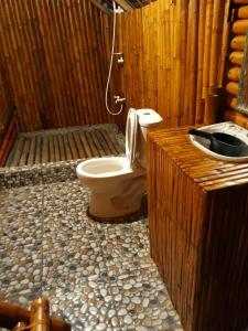 ein Holzbadezimmer mit einem WC und einem Waschbecken in der Unterkunft Magindara Guesthouse in Caramoan