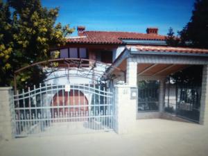 a gate in front of a house with a fence at Apartments villa MaVeRo in Banjole